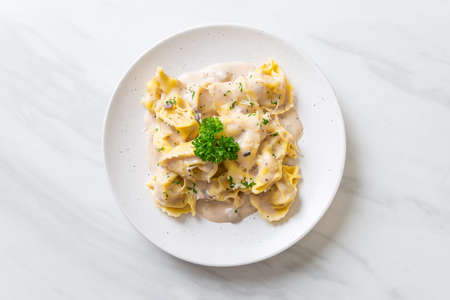 tortellini pasta with mushroom cream sauce and cheese - Italian food styleの写真素材
