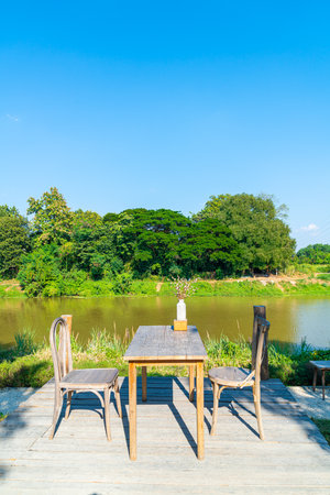 empty table and chair with river view and blue skyの写真素材