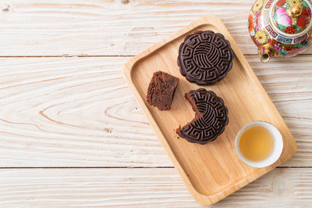 Chinese moon cake dark chocolate flavour on wood plateの写真素材