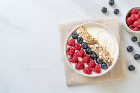 homemade yogurt bowl with raspberry, blueberry and granola  - healthy food styleの写真素材