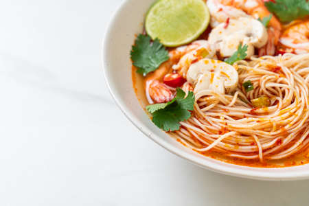 noodles with spicy soup and shrimps in white bowl (Tom Yum Kung)  - Asian food style