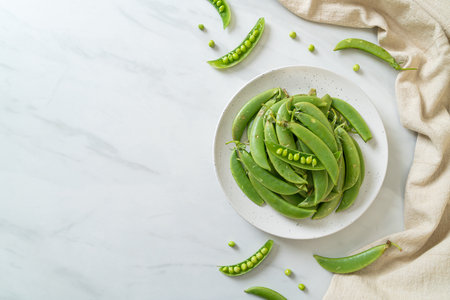 fresh sweet green peas on white plateの写真素材