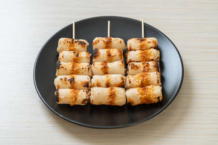 grilled tube shaped fish paste cake or tube squid skewer on plateの写真素材
