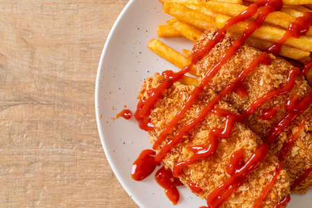 fried chicken breast fillet steak with French fries and ketchup