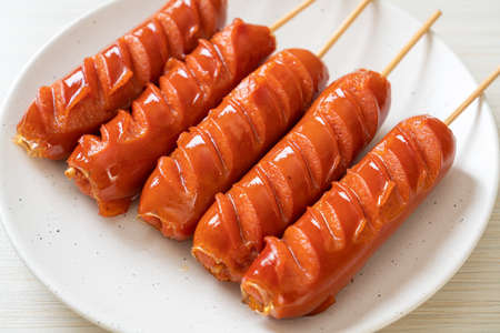 fried sausage skewer on white plateの写真素材