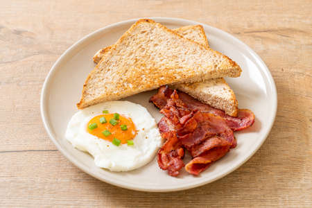 fried egg with bread toasted and bacon for breakfastの写真素材