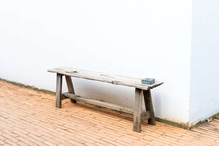 old wood bench with white wallの写真素材