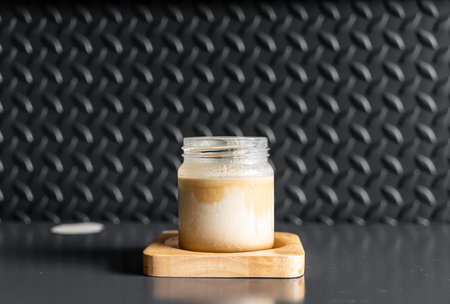 A glass of espresso shot over cold fresh milk create gradient layer called dirty coffee in coffee shopの写真素材