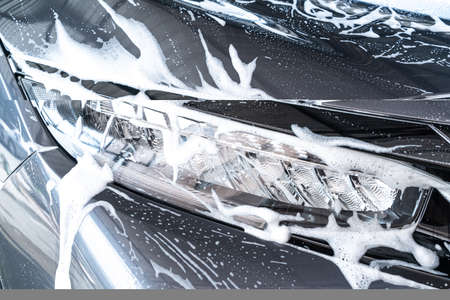 close-up car headlight lamp with car wash foamの写真素材