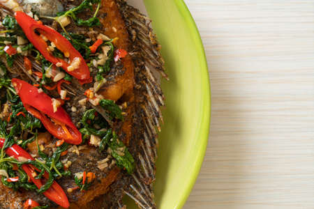 Fried Tilapia Fish with Basil chili garlic sauce on top - homemade food style