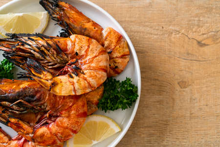 grilled tiger prawns or shrimps with lemon on plateの写真素材