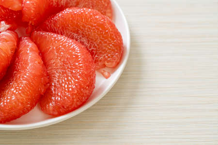 fresh red pomelo fruit or grapefruit on plateの写真素材