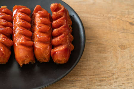 deep fried sausage skewer on black plateの写真素材