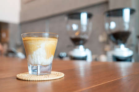 dirty coffee glass (cold milk topped with hot espresso coffee shot) in coffee shopの写真素材
