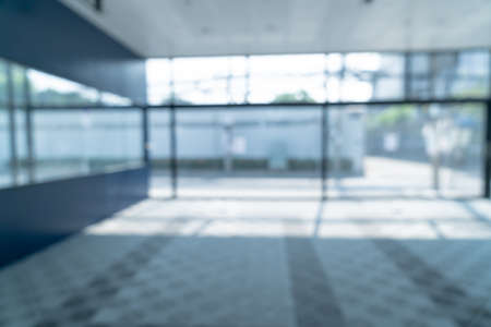 abstract blur empty office with glass window and sunlight for background