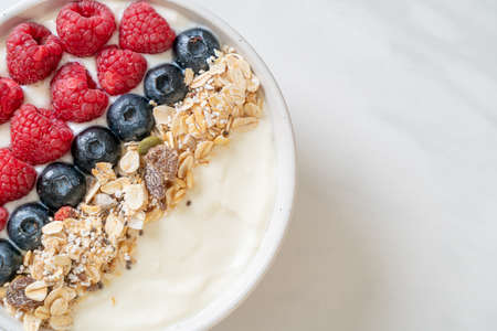 homemade yogurt bowl with raspberry, blueberry and granola  - healthy food styleの写真素材