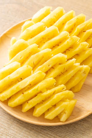 fresh pineapple sliced on wooden plateの写真素材