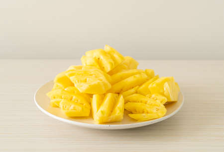 fresh pineapple sliced on white plateの写真素材