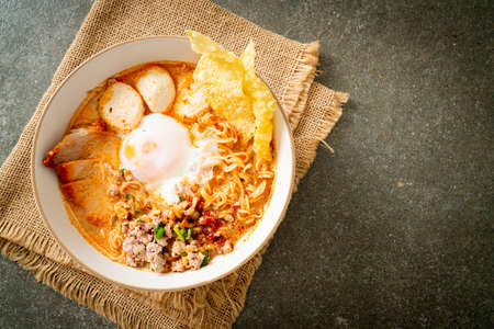 instant noodles with pork and meatballs in spicy soup or Tom Yum Noodles in Asian styleの写真素材