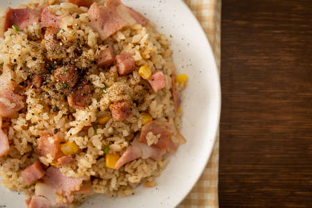 fried rice with bacon ham and black peppers on white plateの写真素材