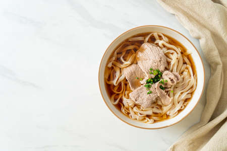homemade udon ramen noodles with pork in soy or shoyu soup