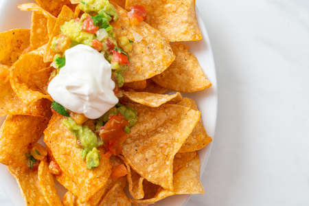 Mexican nachos tortilla chips with jalapeno, guacamole, tomatoes salsa and dipの写真素材