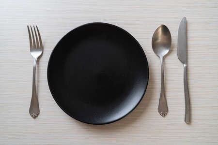 empty plate or dish with knife, fork and spoon on wood tile backgroundの写真素材