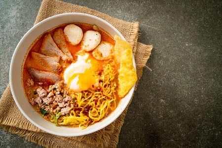 egg noodles with pork and meatball in spicy soup or Tom Yum Noodles in Asian styleの写真素材