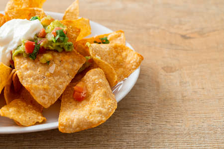 Mexican nachos tortilla chips with jalapeno, guacamole, tomatoes salsa and dip