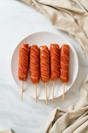 fried sausage skewer on white plateの写真素材