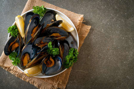 fresh mussels with herbs in a bowl with lemon