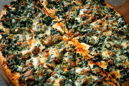 spinach and cheese pizza on wood tray - vegan and vegetarian food styleの写真素材