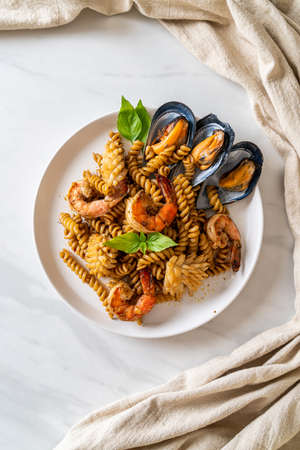 stir-fried spiral pasta with seafood and basil sauce - fusion food styleの写真素材