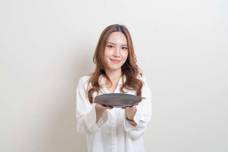 portrait beautiful Asian woman holding empty plate on white backgroundの写真素材