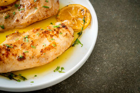 grilled chicken with butter, lemon and garlic on white plateの写真素材