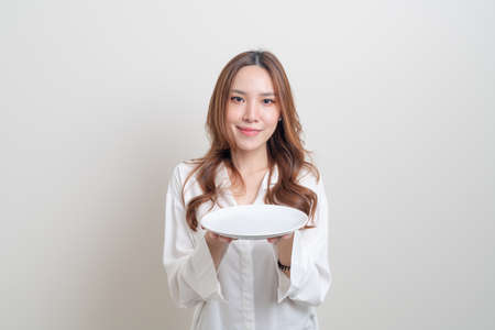 portrait beautiful Asian woman holding empty plate on white backgroundの写真素材