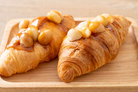 croissant with macadamia and caramel on wood plate