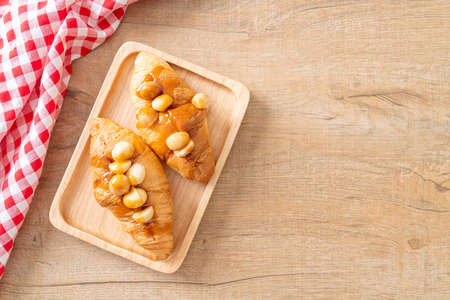 croissant with macadamia and caramel on wood plateの写真素材