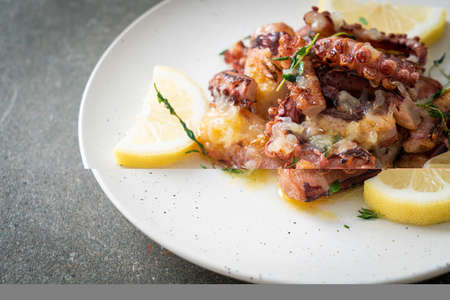 grilled octopus or squid with butter lemon sauce and thymeの写真素材