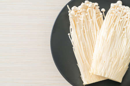 fresh enoki mushroom or golden needle mushrooms on plateの写真素材