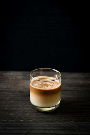 glass of latte coffee, coffee with milk on wood background