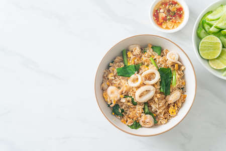 Fried rice with squid or octopus in bowl - stir-fried rice with squid, egg and kaleの写真素材