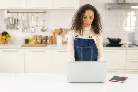 Latin woman searching recipe for cookingの写真素材