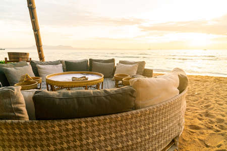 pillows on outdoor patio deck chair on beach with sunset times background