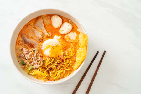 egg noodles with pork and meatball in spicy soup or Tom Yum Noodles in Asian styleの写真素材