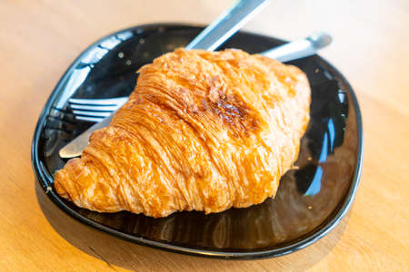 fresh butter croissant on black plate