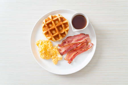 scrambled egg with bacon and waffle for breakfastの写真素材