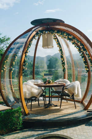 glass dome with dining table and beautiful mountain hill backgroundの写真素材