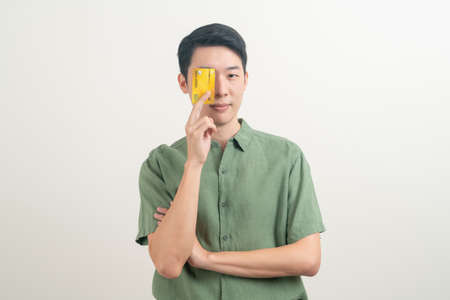 portrait young Asian man holding credit card on white backgroundの写真素材