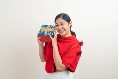 portrait happy Asian woman wearing red shirt with gift box on hand for Christmas festivalの写真素材